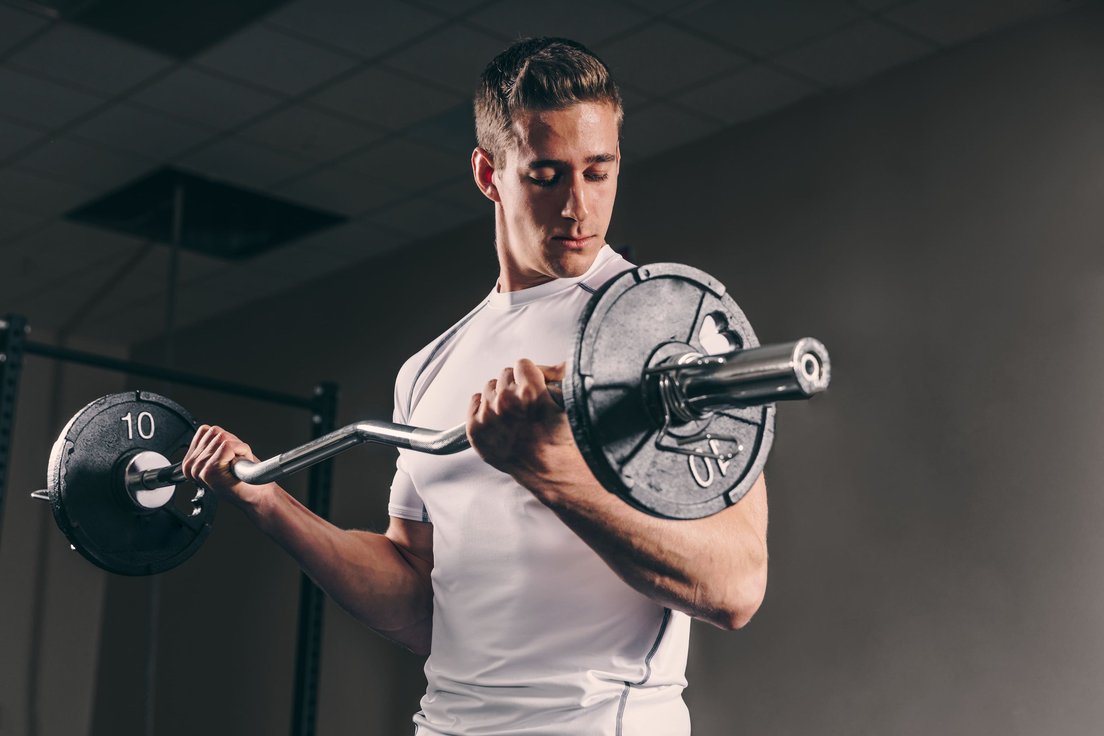 Man lifting a barbell with weights in a gym setting