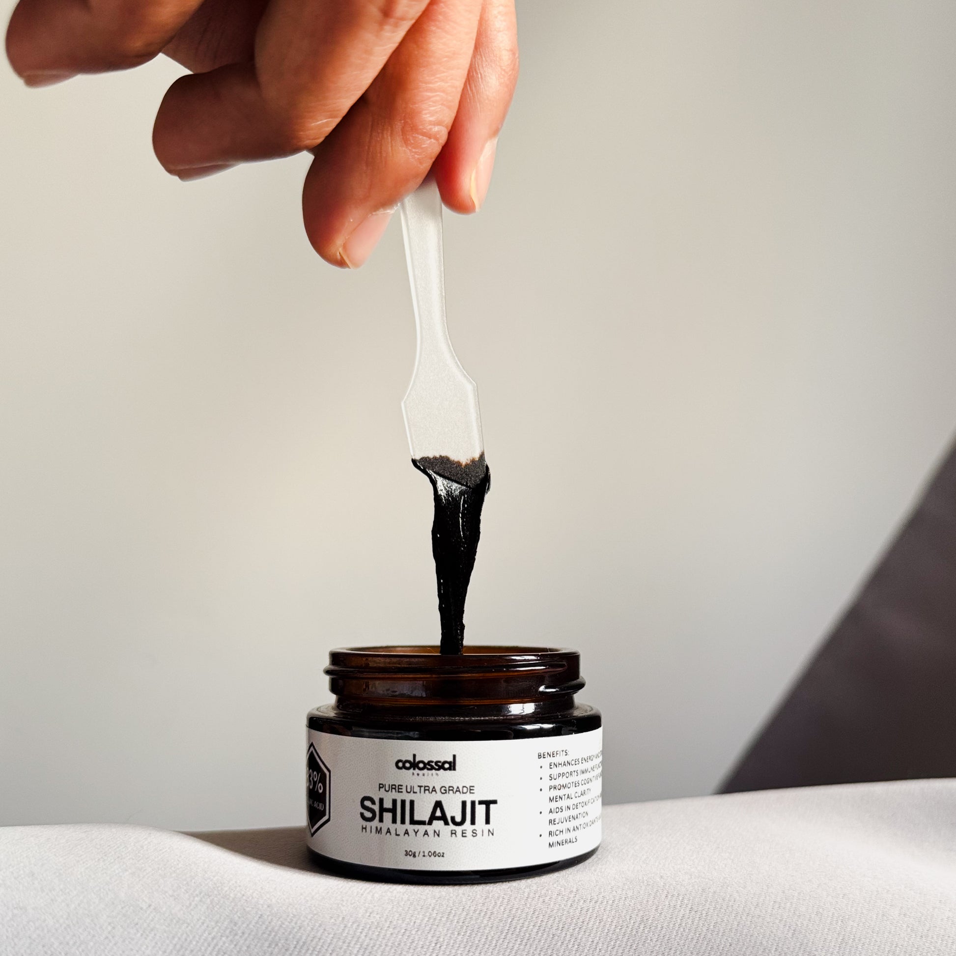 Thick black Shilajit resin close-up showing sticky texture and purity